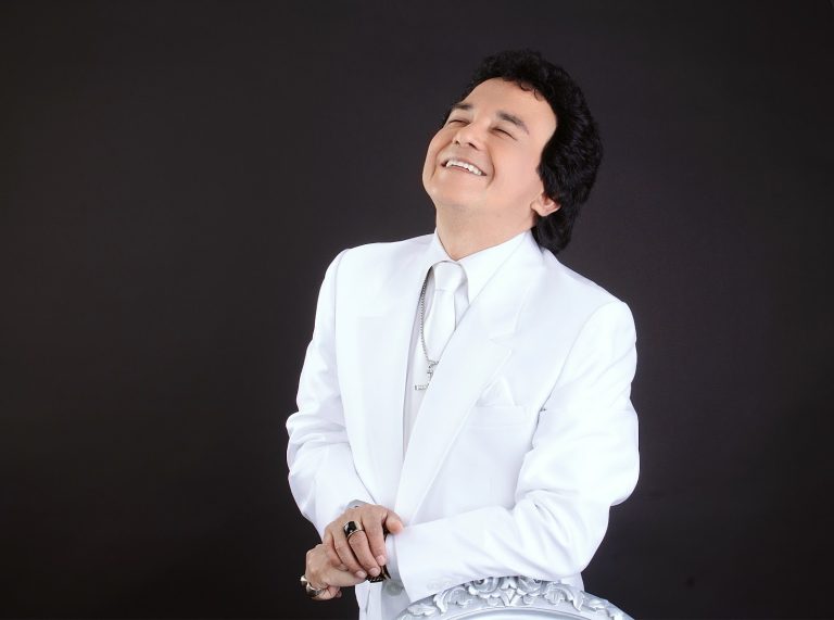Carlos Burga, imitador de José José, sonriendo con traje blanco