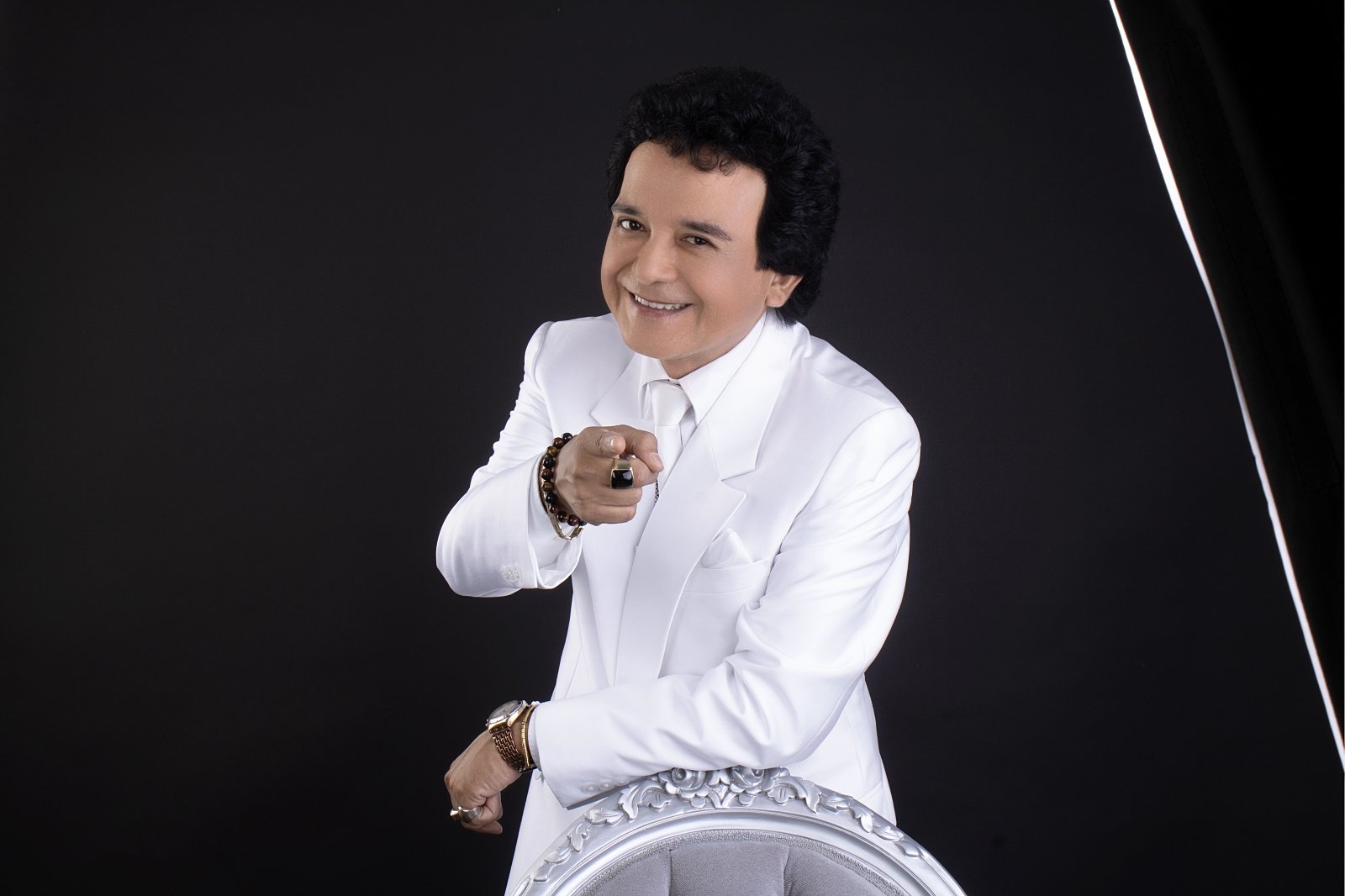 Carlos Burga, Yo Soy José José, con traje blanco señalando a la cámara