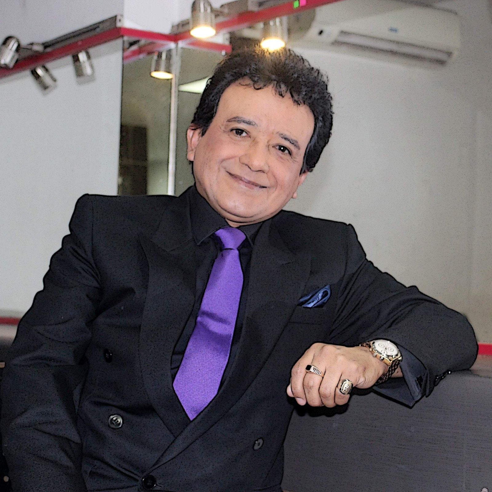 Retrato de Carlos Burga, Yo Soy José José, con traje negro y corbata morada