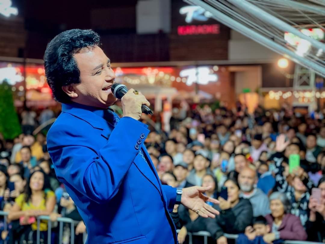 Carlos Burga, Yo Soy José José, cantando con traje azul frente al público