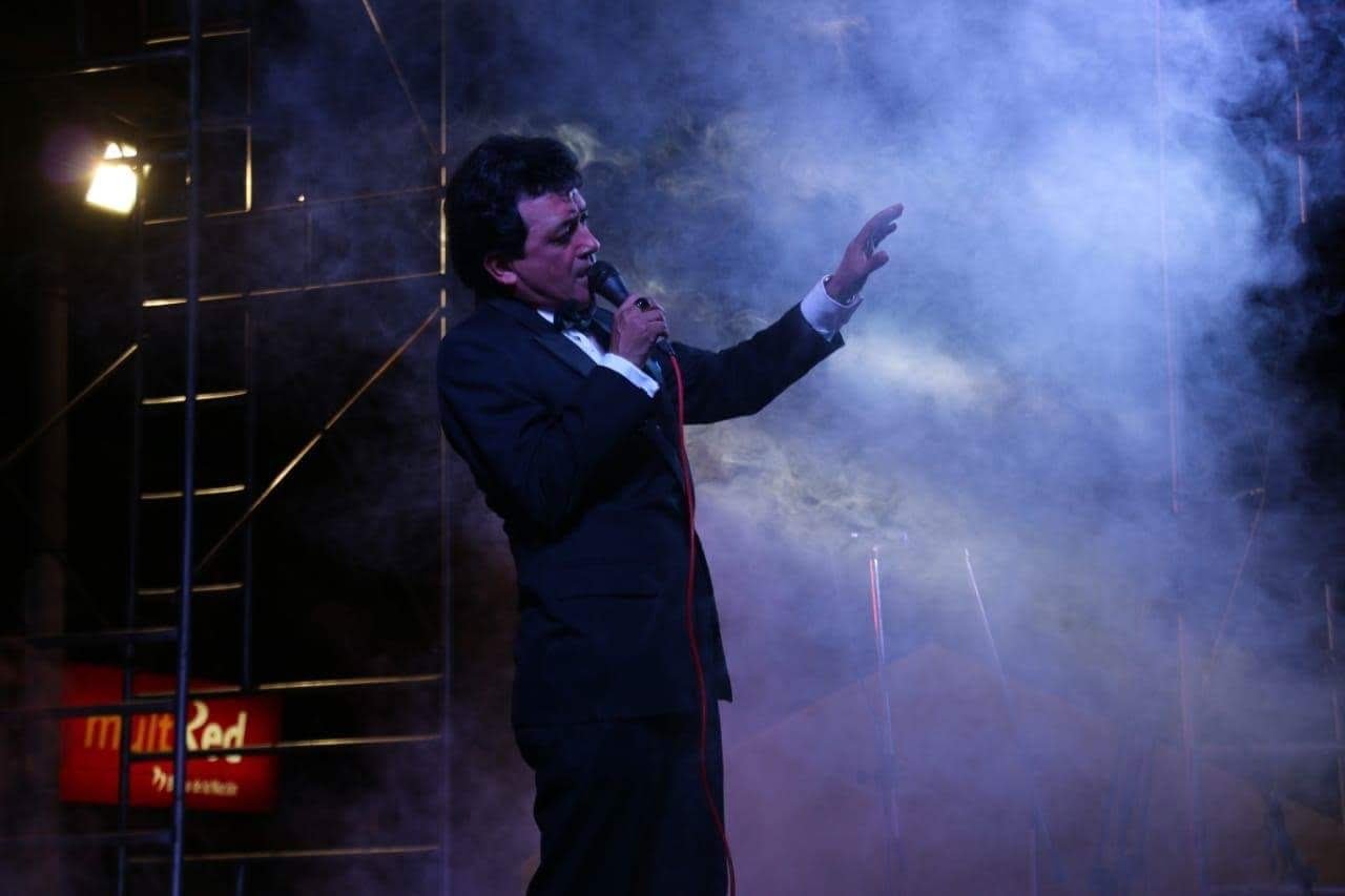 Imitador de José José Carlos Burga cantando entre humo y luces en el escenario