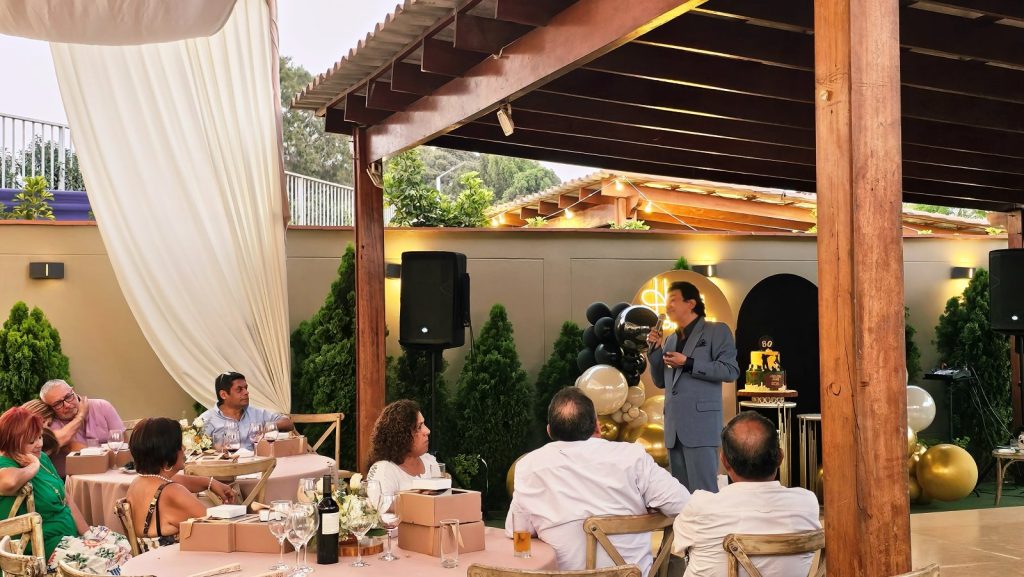 Show de José José en un evento privado en jardín con mesas